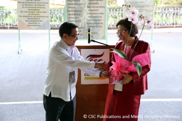 CSC Commissioner Robert S. Martinez hands over a token of appreciation to Prof. Aurora de Dios of Miriam College.
